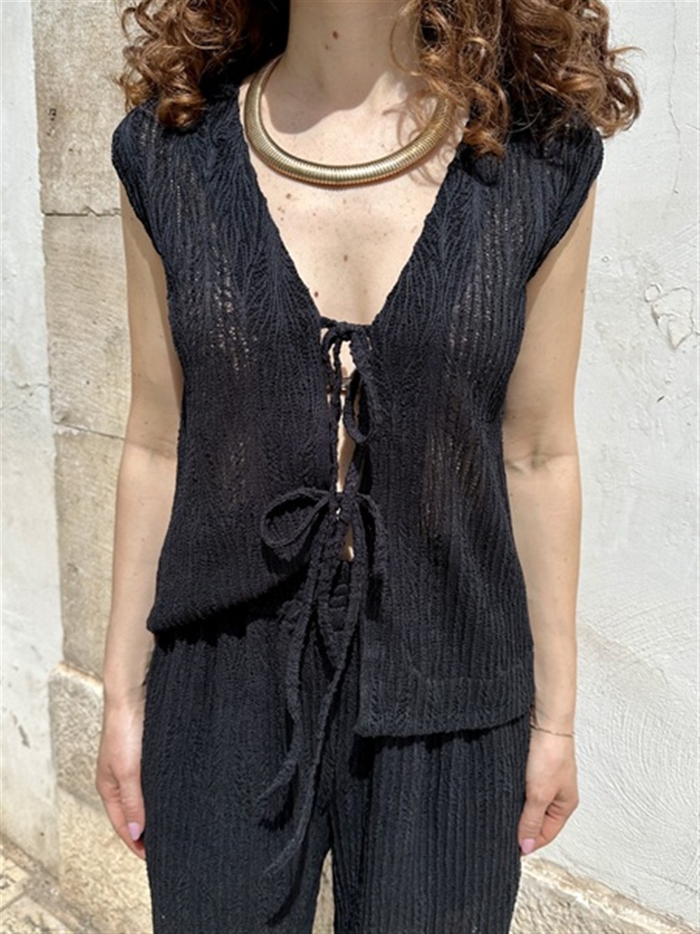 <p>
  Top in pizzo con scollo a v annodato sul davanti effetto gilet nero
</p>Tolérance